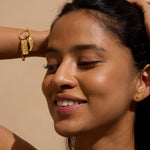 Gold-toned rectangular charm with "444" engraved on beaded bracelet worn on wrist, featuring wing detail on pendant.