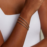The Diamond 14kt Gold Tennis Bracelet adorned on a model's wrist, epitomizing sophistication and charm. This spiritual jewelry piece serves as a talisman for manifestation, aligning with the energies of the sun and moon, and enhancing practices of meditation and yoga for a truly meaningful experience.