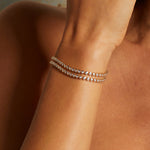 Close-up view of the Diamond 14kt Gold Tennis Bracelet elegantly wrapped around a model's wrist. This stunning bracelet highlights clarity and abundant energy, serving as a spiritual talisman for protection, meaningful meditation practices, and a beautiful addition to any zodiac or yoga collection.