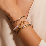 A close view of the Spiritual Evolution Moon Phase Cuff worn alongside other bracelets. This unique piece represents spiritual meaning, protection, and the connection between the sun and moon, enhancing your meditation and zodiac journey.