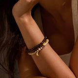 A close-up of the Manifest Balance Gemstone Bracelet Set worn on a wrist, showcasing the harmonious blend of African opal, smokey quartz, and tiger eye. This spiritual jewelry is designed for meaningful meditation and offers protection, aligning with the energies of the sun and moon, making it a perfect talisman for practitioners of yoga and manifestation.