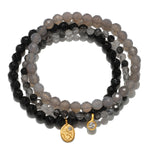 Manifest Fortune Gemstone Bracelet Set featuring a trio of healing gemstones including grey agate, black onyx, and black rutilated quartz. This spiritual jewelry is perfect for meditation and serves as a talisman for protection and manifestation, ideal for those who practice yoga and seek meaningful connections with their zodiac.