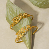 Two Expanding Beauty Lotus Cuffs displayed on a leaf backdrop, highlighting their intricate design and symbolic meanings of transformation and renewal, perfect for talismans in spiritual practices.
