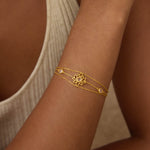 Transformed by Love Lotus Bracelet elegantly displayed on a wrist, featuring a delicate lotus design that symbolizes new beginnings and transformation. This spiritual jewelry piece incorporates rose quartz for healing and love, perfect for meditation and meaningful connections. Ideal for yoga enthusiasts and those seeking spiritual protection and manifestation.