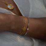 Transformed by Love Lotus Bracelet showcased alongside a pendant, emphasizing its beauty and connection to spiritual meaning. The bracelet embodies love and transformation, making it a perfect talisman for meditation, aiding in manifestation practices and enhancing personal strength.