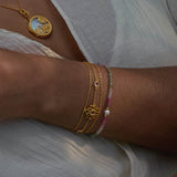 Transformed by Love Lotus Bracelet showcased alongside a pendant, emphasizing its beauty and connection to spiritual meaning. The bracelet embodies love and transformation, making it a perfect talisman for meditation, aiding in manifestation practices and enhancing personal strength.