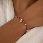 Close-up view of the Amethyst Lotus February Birthstone Bracelet worn on a wrist, showcasing the beautiful lotus pendant and amethyst stones. This striking spiritual jewelry piece represents transformation and is a wonderful addition to your collection of malas, perfect for daily meditation and connecting with your inner self.
