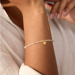 Aquamarine Lotus March Birthstone Bracelet worn on a woman's wrist, showcasing its delicate aquamarine stones and elegant gold lotus charm, ideal for yoga enthusiasts and those drawn to meaningful spiritual talismans for protection and personal growth.