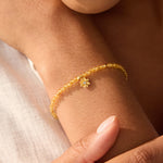 Close-up view of the Citrine Lotus November Birthstone Bracelet worn on a wrist, showcasing its elegant design with faceted round citrine and white topaz stones. This piece of spiritual jewelry serves as a radiant reminder of individuality and growth, perfect for meditation and as a talisman for those seeking meaning and connection to their zodiac. A stylish accessory for yoga practice that symbolizes happiness and protection.
