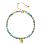 Turquoise Lotus December Birthstone Bracelet showcasing vibrant turquoise beads and an 18kt gold plated lotus flower pendant, symbolizing new beginnings. This piece represents spiritual jewelry perfect for meditation, serving as a talisman for manifestation and protection, ideal for those interested in zodiac and yoga.