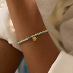 Close-up of the Turquoise Lotus December Birthstone Bracelet worn elegantly, featuring turquoise beads and a gold lotus flower pendant, emphasizing handmade spiritual jewelry. Ideal for meditation and meaningful practices, this bracelet serves as a talisman for protection, healing, and manifestation in yoga and daily life.