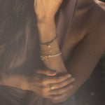Close-up of the Goddess Wisdom Moonstone Beaded and Chain Toggle Bracelet paired with other bracelets, emphasizing its spiritual significance and connection to the sun and moon in your wellness journey.