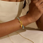 The Tranquil Spirit Aquamarine Heart Toggle Bracelet on a wrist, showcasing its radiant aquamarine and gold elements. This spiritual jewelry piece is ideal for meditation and serves as a meaningful talisman for zodiac enthusiasts, promoting protection and peace while enhancing yoga practices under the sun and moon.