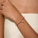 Comforted by Love Rhodonite Heart Bracelet worn elegantly on a wrist, showcasing the beautiful heart pendant and soft rhodonite beads. This spiritual piece is ideal for those interested in meditation and manifestation, embodying the essence of love and protection within their yoga practice.