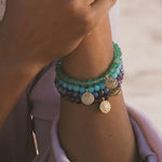 Close-up of a Throat Chakra Amazonite Stretch Bracelet with a 12mm gold-plated charm, perfect for anyone interested in spiritual jewelry and meaningful talismans. This bracelet is designed to aid meditation, enhance communication, and resonate with the energies of the sun and moon.