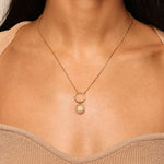 A close-up view of the Shining Sun White Topaz Charm, displayed on a gold chain around a person's neck. This spiritual jewelry piece is designed to channel vitality and leadership, making it a meaningful talisman for meditation and manifestation practices. The charm features a radiant sun motif, symbolic of energy and awareness, perfect for those engaged in yoga and seeking spiritual protection.
