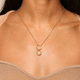 A close-up view of the Shining Sun White Topaz Charm, displayed on a gold chain around a person's neck. This spiritual jewelry piece is designed to channel vitality and leadership, making it a meaningful talisman for meditation and manifestation practices. The charm features a radiant sun motif, symbolic of energy and awareness, perfect for those engaged in yoga and seeking spiritual protection.