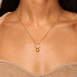 A woman wearing the Heart Charm necklace, showcasing an 18kt gold plated puffy heart pendant symbolizing love and compassion. This spiritual jewelry piece serves as a meaningful charm for meditation and manifestation. Ideal for zodiac enthusiasts and yoga practitioners, it embodies protection and the essence of the sun and moon.