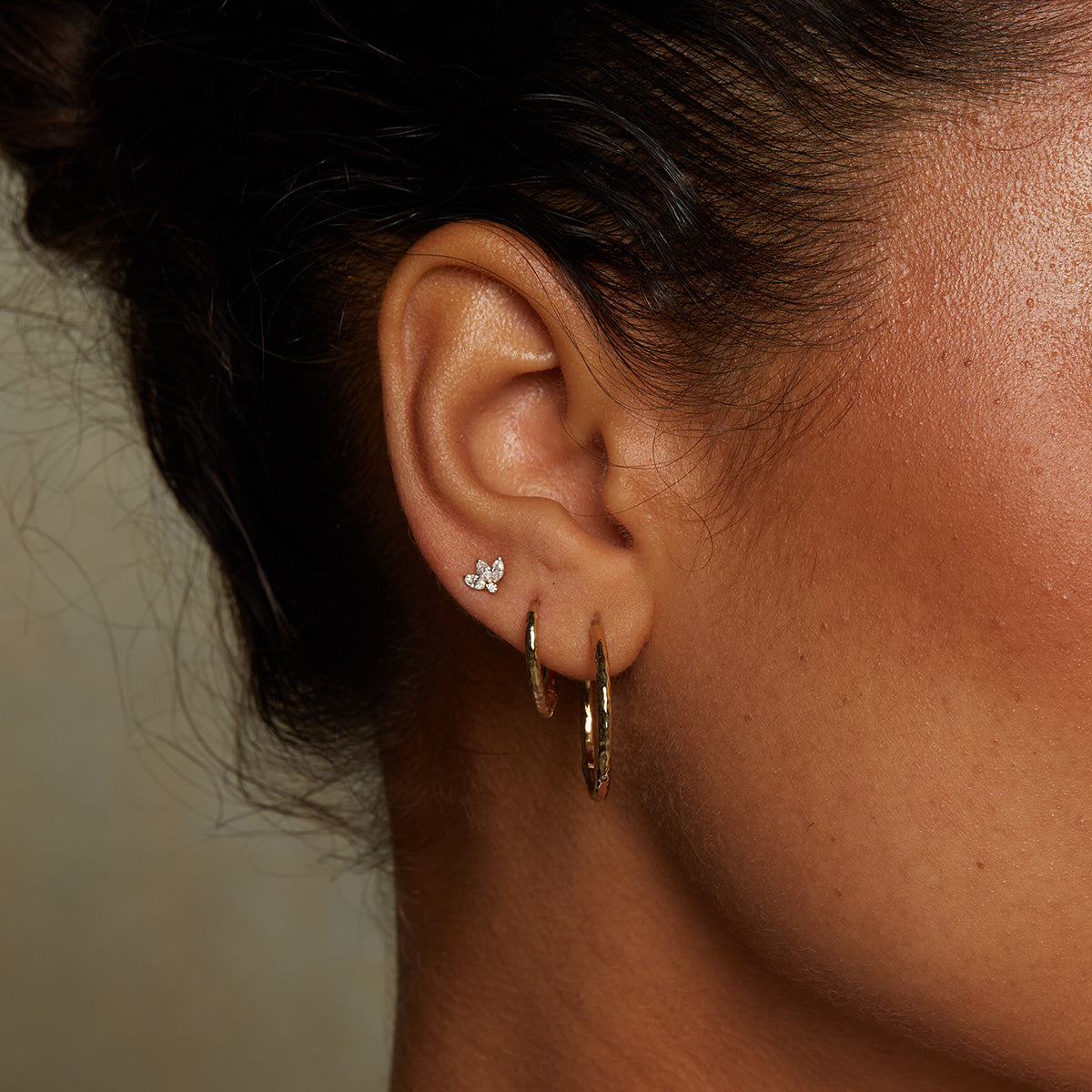A model wearing Medium Hoop 14kt Gold Earrings, highlighting their timeless beauty as spiritual jewelry. These earrings complement any outfit, embodying the essence of yoga and zodiac influences while symbolizing meaningful connections and protection.