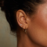 A model wearing Medium Hoop 14kt Gold Earrings, highlighting their timeless beauty as spiritual jewelry. These earrings complement any outfit, embodying the essence of yoga and zodiac influences while symbolizing meaningful connections and protection.