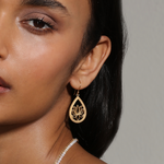 Close-up of a model wearing the Open to Possibilities Lotus Earrings, showcasing their intricate design. These earrings are a beautiful piece of spiritual jewelry, ideal for those seeking meaning, charm, and inspiration in their yoga and meditation journey.
