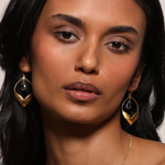 A model wearing the Transformed by Compassion Lotus Blue Topaz Earrings, beautifully framed to highlight the elegant 18kt gold plated lotus design. The blue topaz gemstones add charm and significance, making this spiritual jewelry a great addition to any yoga or meditation practice, embodying the essence of meaning and spirituality.