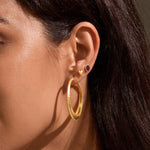 Close-up of Timeless Beauty Dot Hoop Earrings worn by a woman in a chic setting, highlighting their luxurious design. This pair of spiritual jewelry embodies elegance and meaning, making it a great addition to any ear stack. Ideal for those interested in talismans, zodiac influences, and the deep connection to meditation and yoga practice.