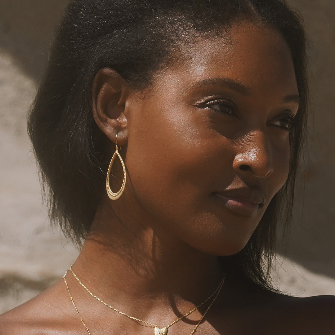 A model showcasing the Graceful Beauty Dot Teardrop Earrings, highlighting their elegance, ideal for meaningful moments in meditation and spiritual protection designed as a fashionable talisman for manifestation.