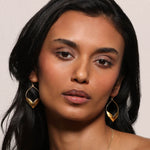 Model showcasing Fluttering Petals Gold Earrings, crafted with open-work petals plated in 18kt gold. These timeless spiritual jewelry pieces symbolize new beginnings and transformation, combining elegance with meaningful design. Perfect for manifestation, meditation, yoga, or adding to a talisman collection, enhancing your protection and connection to the sun and moon.