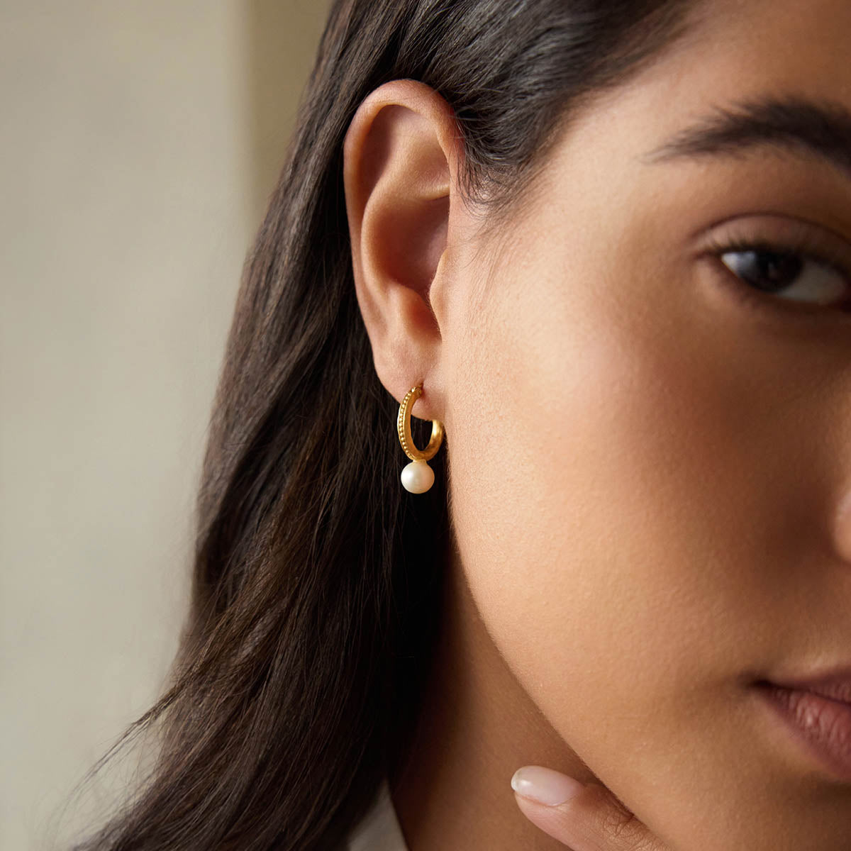 Nature's Harmony Pearl Hoop Earrings worn by a model, showcasing the delicate 18kt gold plate and lustrous mother of pearl. This spiritual jewelry piece embodies beauty and positivity, making it a perfect talisman for meditation and manifestation.