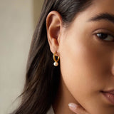 Nature's Harmony Pearl Hoop Earrings worn by a model, showcasing the delicate 18kt gold plate and lustrous mother of pearl. This spiritual jewelry piece embodies beauty and positivity, making it a perfect talisman for meditation and manifestation.