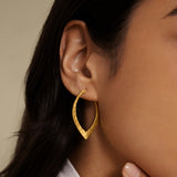 In Transformation Hoop Earrings displayed on a model, showcasing their elegant design that represents spiritual growth and renewal. These meaningful earrings serve as a talisman for protection and inspiration, complementing your journey through meditation and connection with the sun and moon.