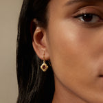 Close-up of the Strong Heart Garnet Drop Earrings worn by a model, highlighting the detailed lotus petal design and red garnet stone. These earrings serve as a beautiful talisman for protection and spiritual growth, making them a great addition to any meditation or yoga practice.