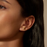 Grounding Energy Garnet Stud Earrings worn by a model, illustrating their elegant design and the deep red garnet stones, ideal for those interested in zodiac-inspired spiritual jewelry. These studs symbolize connection to the earth and serve as a beautiful addition to any yoga practice or meaningful manifestation journey.