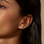 Tap Into Intuition Labradorite Stud Earrings worn by a model, showcasing their delicate design with 18kt gold plating. These spiritual jewelry pieces symbolize intuition and are perfect for meditation and manifestation. Ideal for yoga practitioners and those seeking meaningful talismans for spiritual protection, they embody a connection to the sun and moon, enhancing one's spiritual journey.