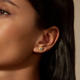 Tap Into Intuition Labradorite Stud Earrings worn by a model, showcasing their delicate design with 18kt gold plating. These spiritual jewelry pieces symbolize intuition and are perfect for meditation and manifestation. Ideal for yoga practitioners and those seeking meaningful talismans for spiritual protection, they embody a connection to the sun and moon, enhancing one's spiritual journey.