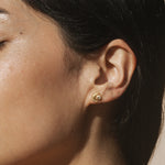 A close-up of a model wearing the Guiding Star Celestial White Topaz Stud Earrings, showcasing the intricate crescent moon and sun design. These earrings emphasize a blend of spiritual and meaningful aesthetics, making them ideal for meditation, talismanic power, and enhancing your journey through yoga and self-discovery.