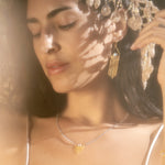 A close-up of a woman wearing the Cascade of Starlight Moonstone Fringe Drop Earrings, radiating feminine energy. The earrings symbolize the sun and moon, making them a meaningful addition to spiritual jewelry for meditation and zodiac practices.
