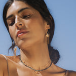 A side profile of a woman with the Cascade of Starlight Moonstone Fringe Drop Earrings, capturing the beauty of spiritual and meaningful jewelry. The design reflects the influence of the sun and moon, perfect for meditation and zodiac enthusiasts.