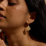Close-up of a model wearing the Awakened by Love Rose Quartz Lotus Petal Earrings, emphasizing the delicate lotus petals and pear-shaped rose quartz. This spiritual jewelry piece is perfect for those seeking meaning in their accessories, serving as a powerful talisman during meditation and yoga, and symbolizing love, protection, and personal transformation.