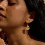 Close-up of a model wearing the Awakened by Love Rose Quartz Lotus Petal Earrings, emphasizing the delicate lotus petals and pear-shaped rose quartz. This spiritual jewelry piece is perfect for those seeking meaning in their accessories, serving as a powerful talisman during meditation and yoga, and symbolizing love, protection, and personal transformation.