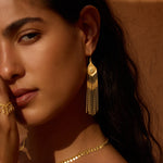 Gold dangle earrings with circular opal tops and chain fringe strands, worn on model.