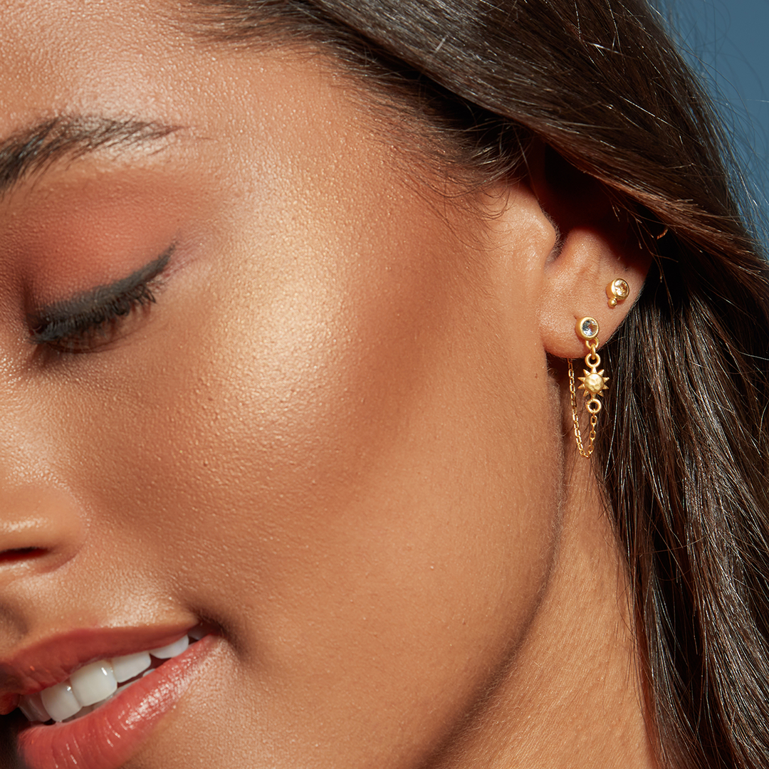 Close-up of a model wearing Promise of Magic Earrings featuring blue topaz and sun and moon pendants, embodying the essence of spiritual jewelry, meditation, and meaningful manifestation.