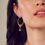 A close-up of the Brilliant Beginnings Earrings showcased on a model, designed with lotus flowers symbolizing new beginnings, crafted from 18kt gold plate, perfect for spiritual jewelry, meditation gifts, and a meaningful accessory for yoga enthusiasts. These earrings embody the essence of manifestation with a protective, sacred charm.