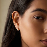 A close-up of a model wearing Textured Sterling Silver Mini Hoop Earrings, highlighting their minimalist charm and connection to spiritual practices, ideal for yoga enthusiasts and those who value the meaning behind their jewelry.