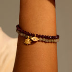 Loving Protection Garnet Evil Eye Bracelet paired with complementary stones, emphasizing its vibrant garnet and eye charm. This spiritual piece is ideal for enhancing meditation practices and serves as a talisman for protection, carrying deep meaning for manifestation and spiritual journeys.