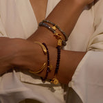 Loving Protection Garnet Evil Eye Bracelet displayed elegantly on a woman's wrist, showcasing the garnet stone and gold plate charm, exemplifying spiritual jewelry that embodies protection, meditation, and meaningful manifestation. This piece serves as a talisman for grounding energies, making it a perfect addition to yoga practice and connecting with the zodiac.