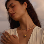 A model wears the Guiding Spirit Labradorite and White Topaz Lotus Locket Necklace, showcasing the necklace as part of a stylish look, symbolizing protection and spirituality, perfect for yoga enthusiasts and those pursuing meaningful connections.