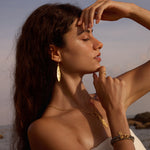 A model showcasing the Manifesting Dreams White Topaz Petal Ring along with other spiritual jewelry, embodying harmony with nature and enhancing meditation, meaning, and personal protection while celebrating the sun and moon.