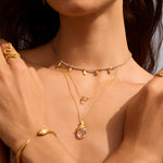 The Manifest Rebirth White Topaz Snake Necklace layered with other jewelry pieces, showcasing a stylish look for yoga enthusiasts and those interested in spiritual jewelry, reflecting the significance of zodiac signs and personal meaning.